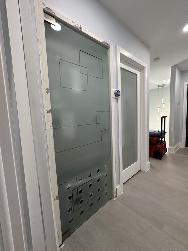 Frosted glass door with a clear geometric line and circle pattern in a hallway